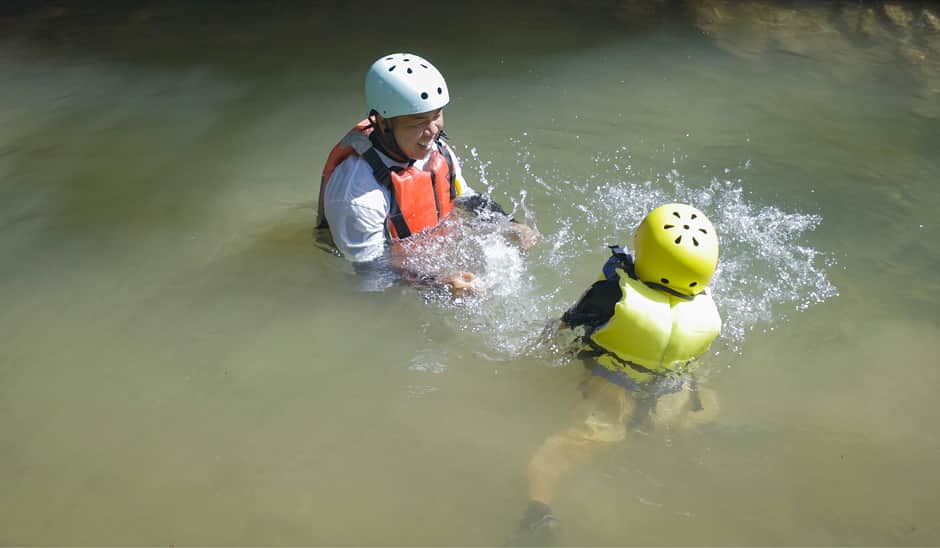 子どもと一緒に水に入って遊ぶ様子